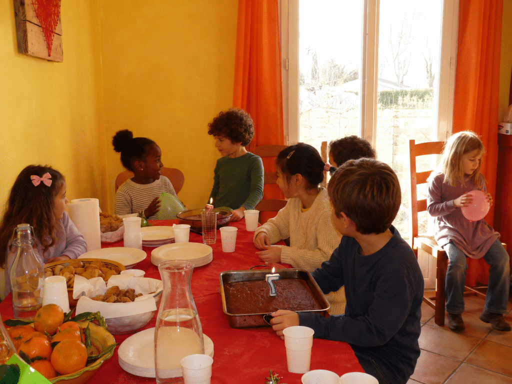table de goûter d'anniversaire d'enfant avec crêpes, fruits séchés, fruits frais et carafe d'eau